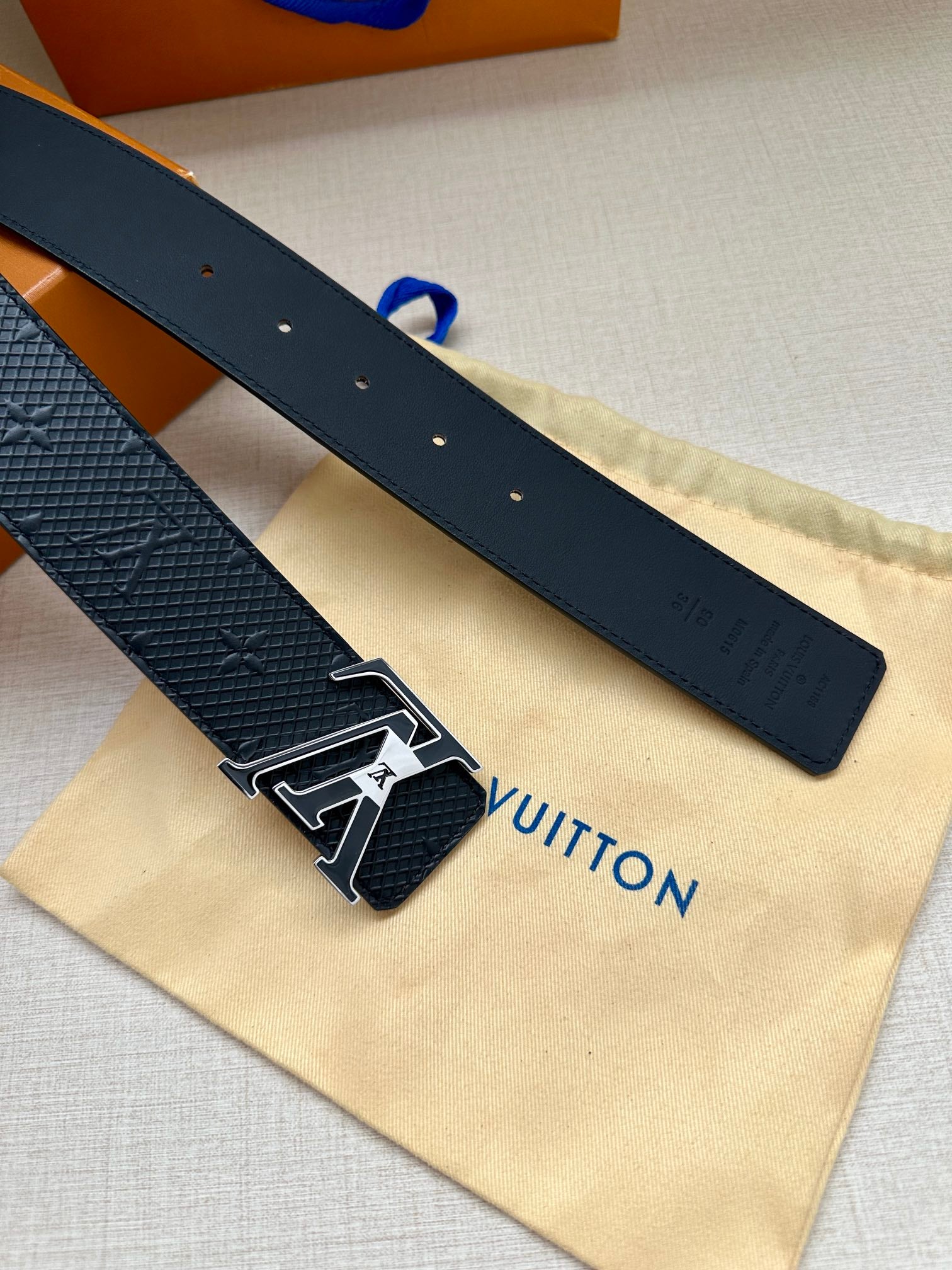 Textured dark blue belt straps with silver-tone buckle and LV emblem