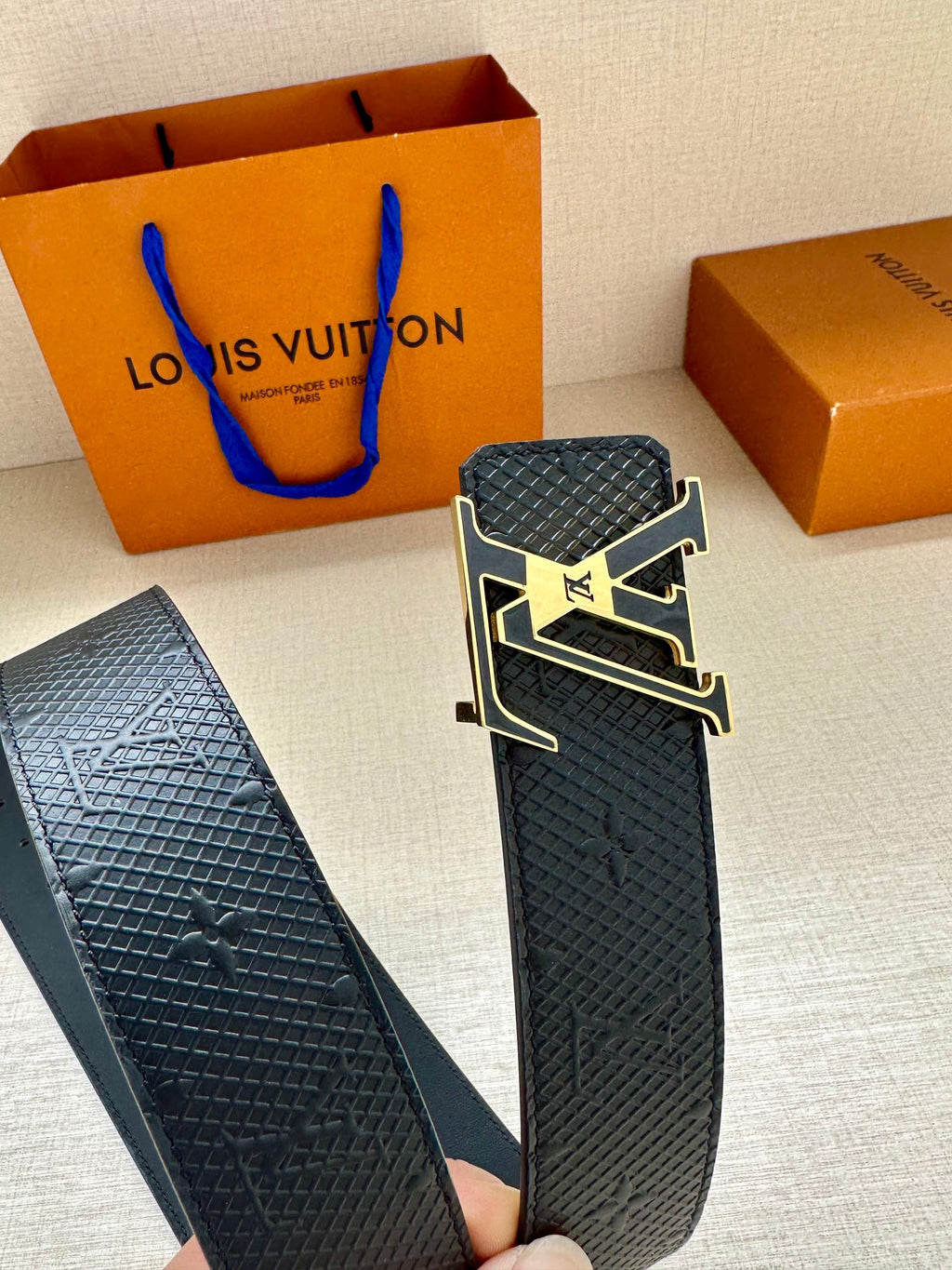 Textured dark blue leather belt with oversized silver-and-gold LV buckle