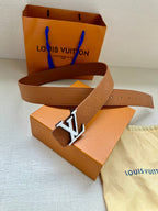 Tan Louis Vuitton belt with monogram strap and silver LV buckle laid flat