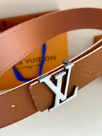 Tan Louis Vuitton belt close-up with monogram strap and silver-toned LV buckle