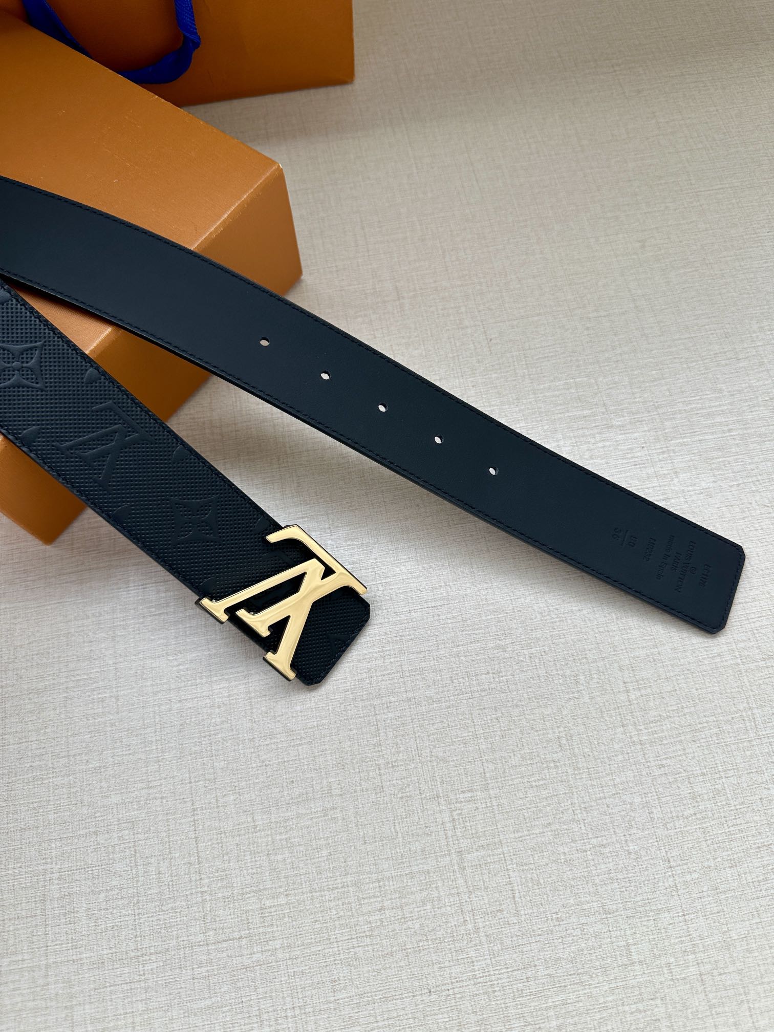 Louis Vuitton leather belt strap with dark navy embossed finish and gold-tone LV buckle