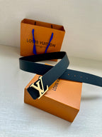 Louis Vuitton belt laid out on box: dark navy embossed leather with gold-tone LV buckle