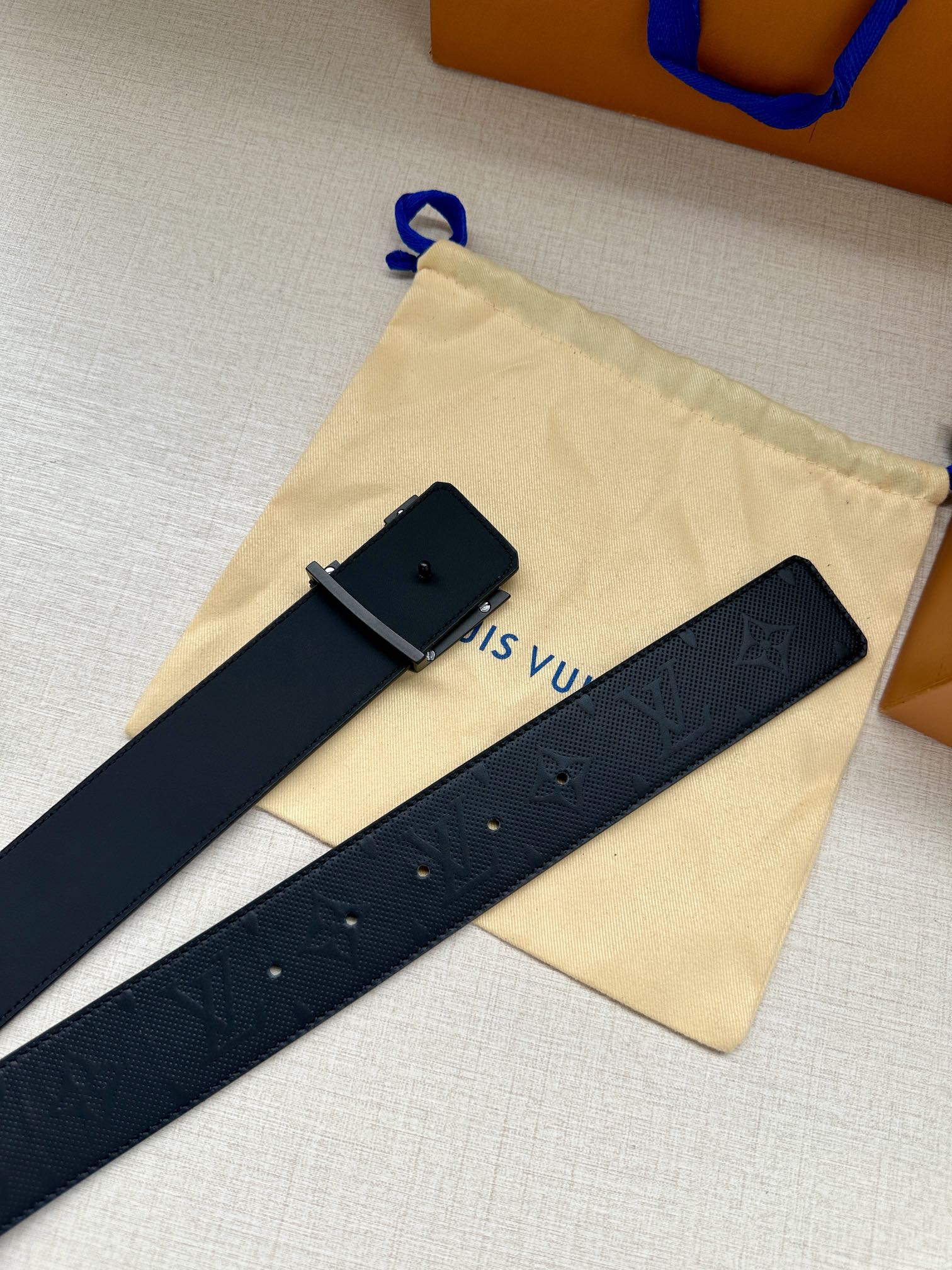 Louis Vuitton belt on dust bag: dark navy embossed strap with square dark buckle tab