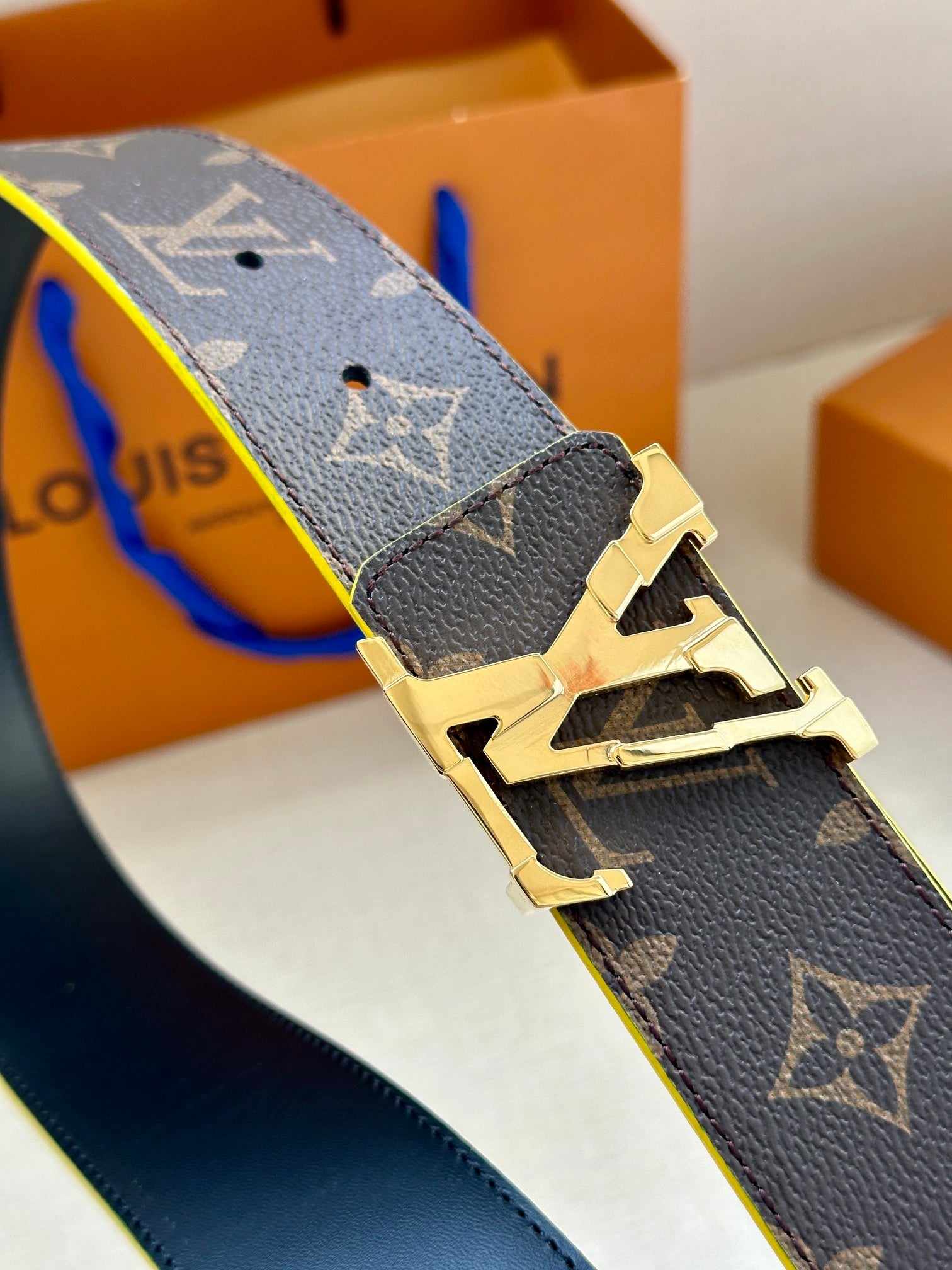 Louis Vuitton monogram belt buckle detail with gold hardware and blue edge trim