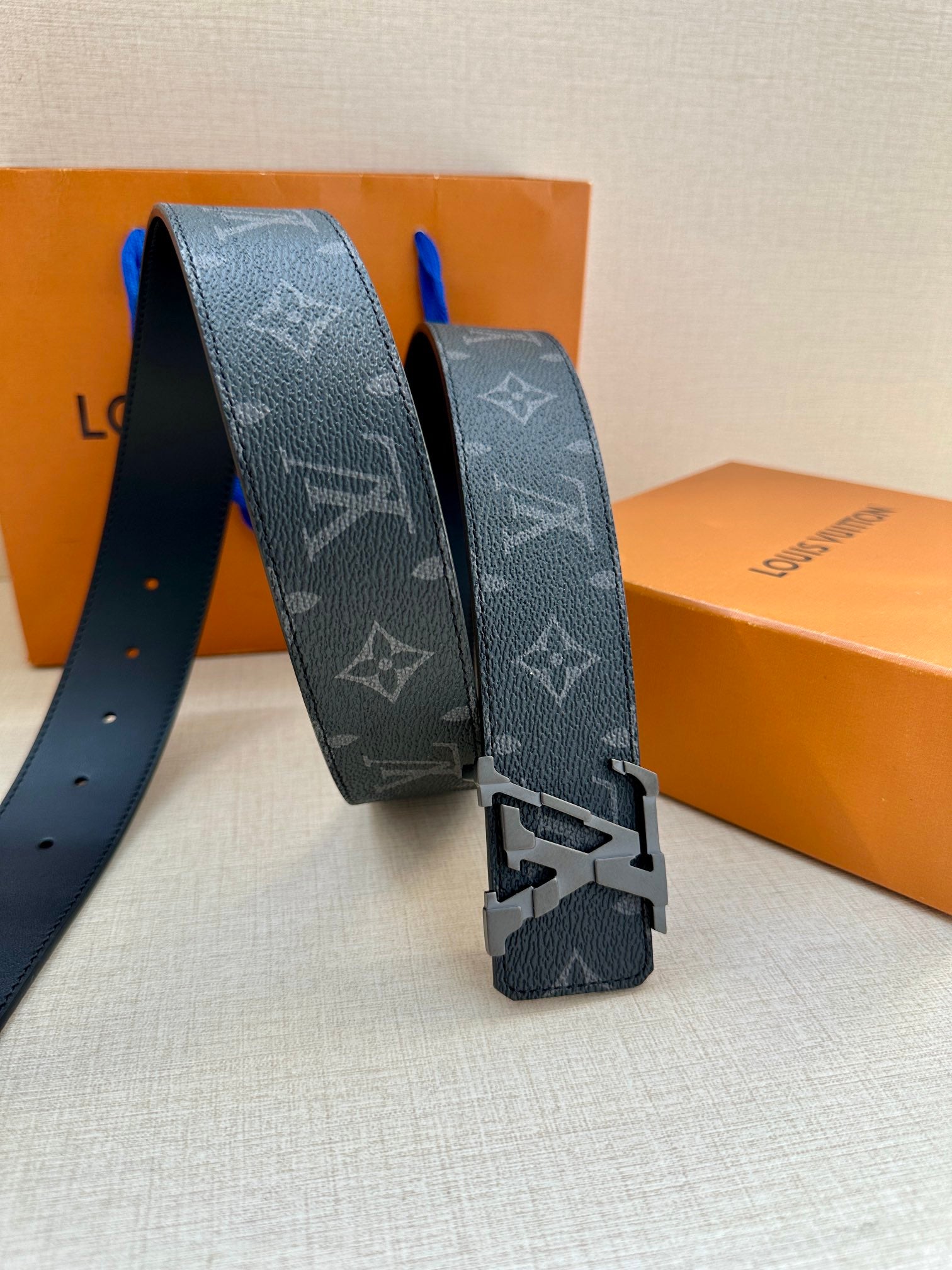 Louis Vuitton monogram belt with dark patterned strap and silver buckle hardware.