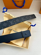 Louis Vuitton monogram belt with dark strap, silver buckle, and blue pull loop.