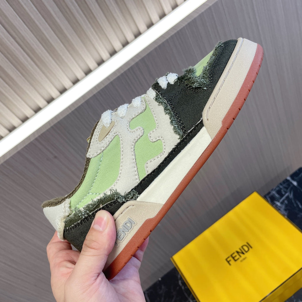 Fendi low-top sneaker in hand, lime green/black upper, white laces, cream sole.