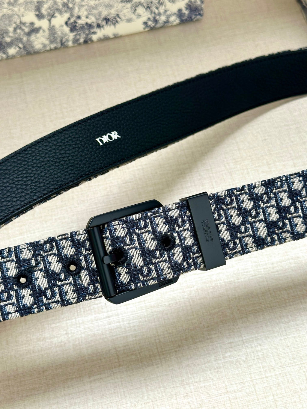 Louis Vuitton belt close-up: blue monogram strap with black rectangular buckle