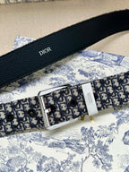 Dior belt detail with black leather strap, engraved logo text, and silver buckle
