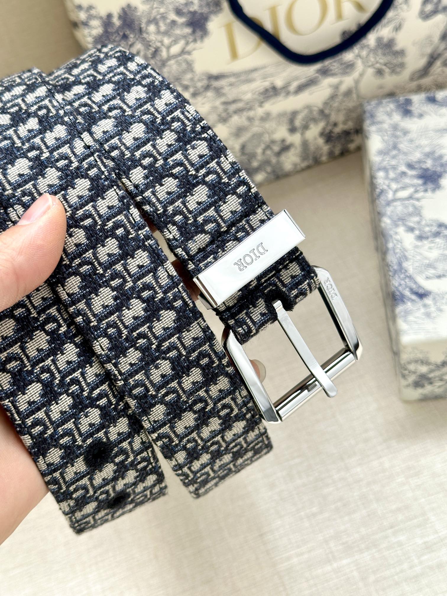 Dior belt buckle and strap close-up with repeating monogram pattern