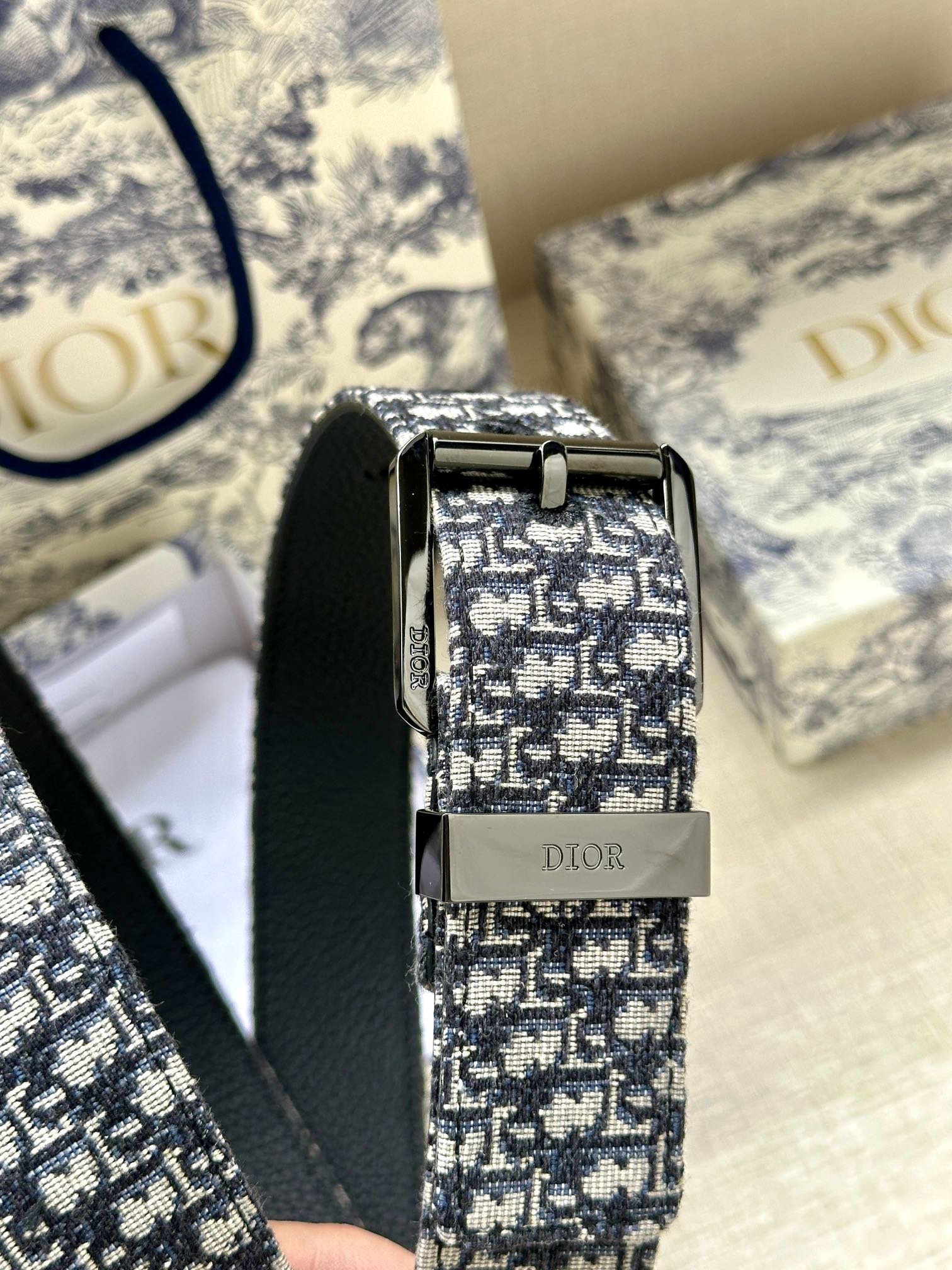 Dior belt close-up: blue jacquard strap with silver buckle and black leather underside