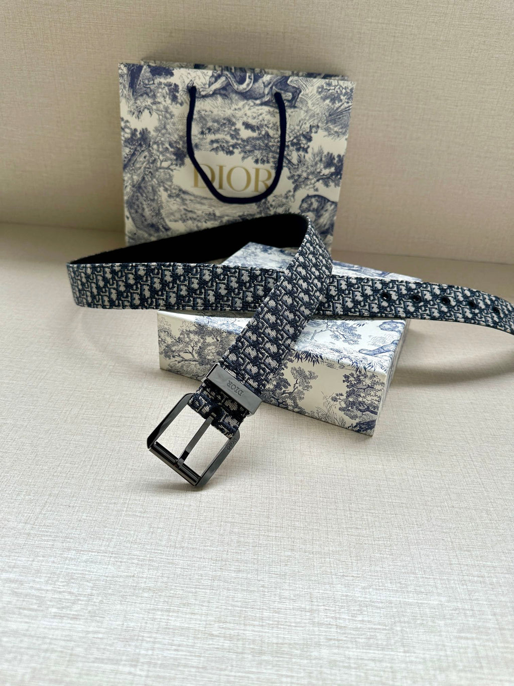 Dior belt laid flat: blue monogram jacquard strap with square pin-buckle