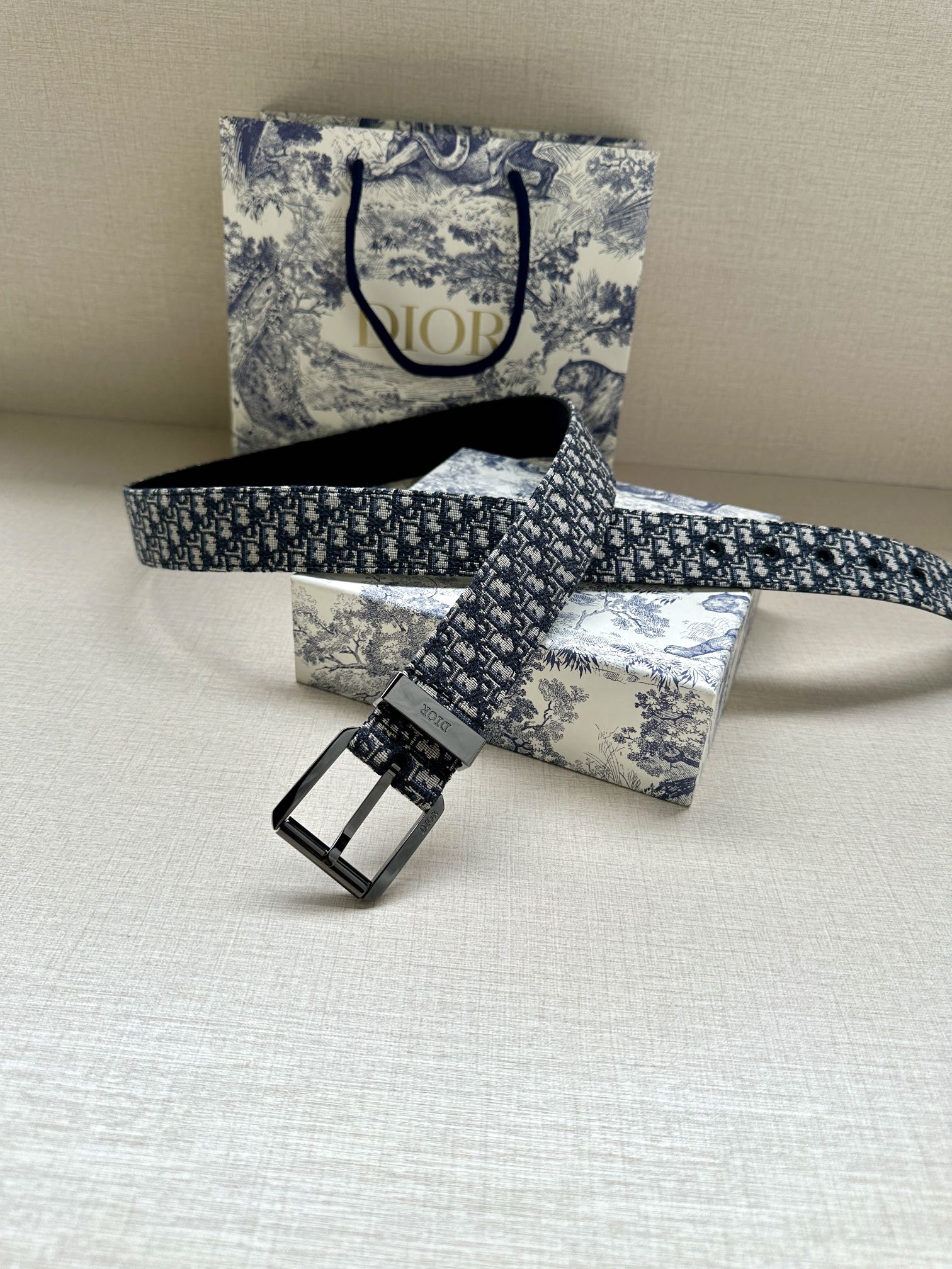 Dior belt laid flat: blue monogram jacquard strap with square pin-buckle