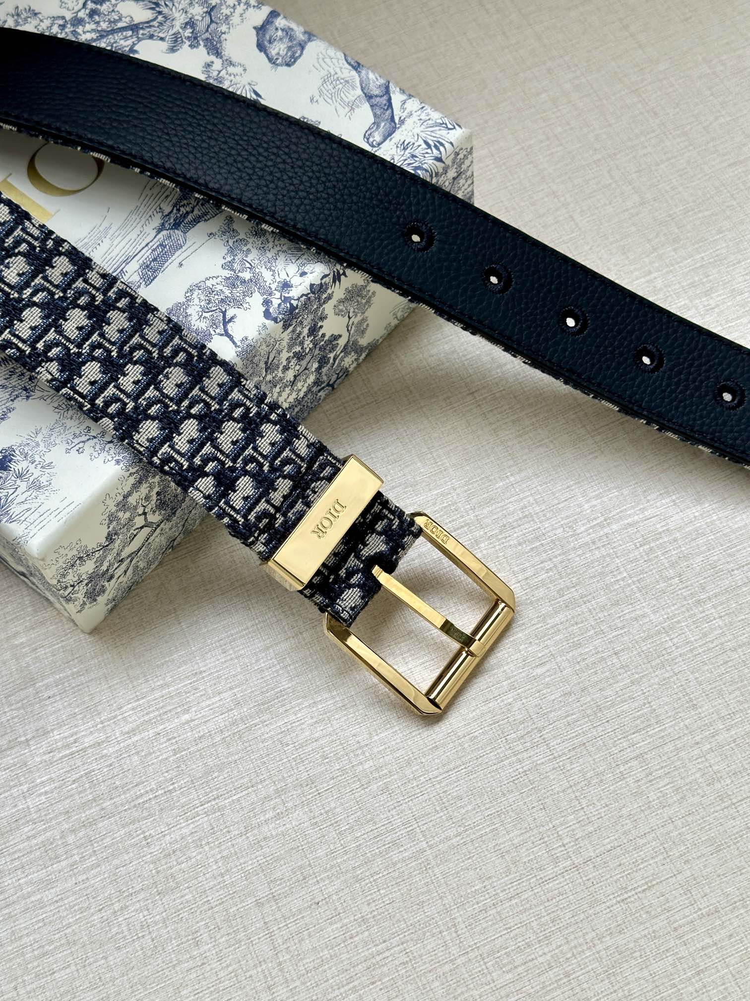 Navy leather-back Dior belt with gold buckle and multiple adjustment holes