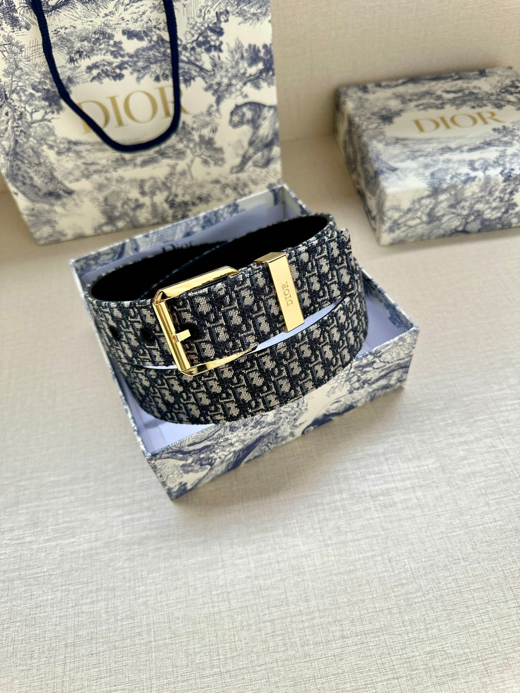 Dior monogram belt with gold buckle shown in box and black belt underside