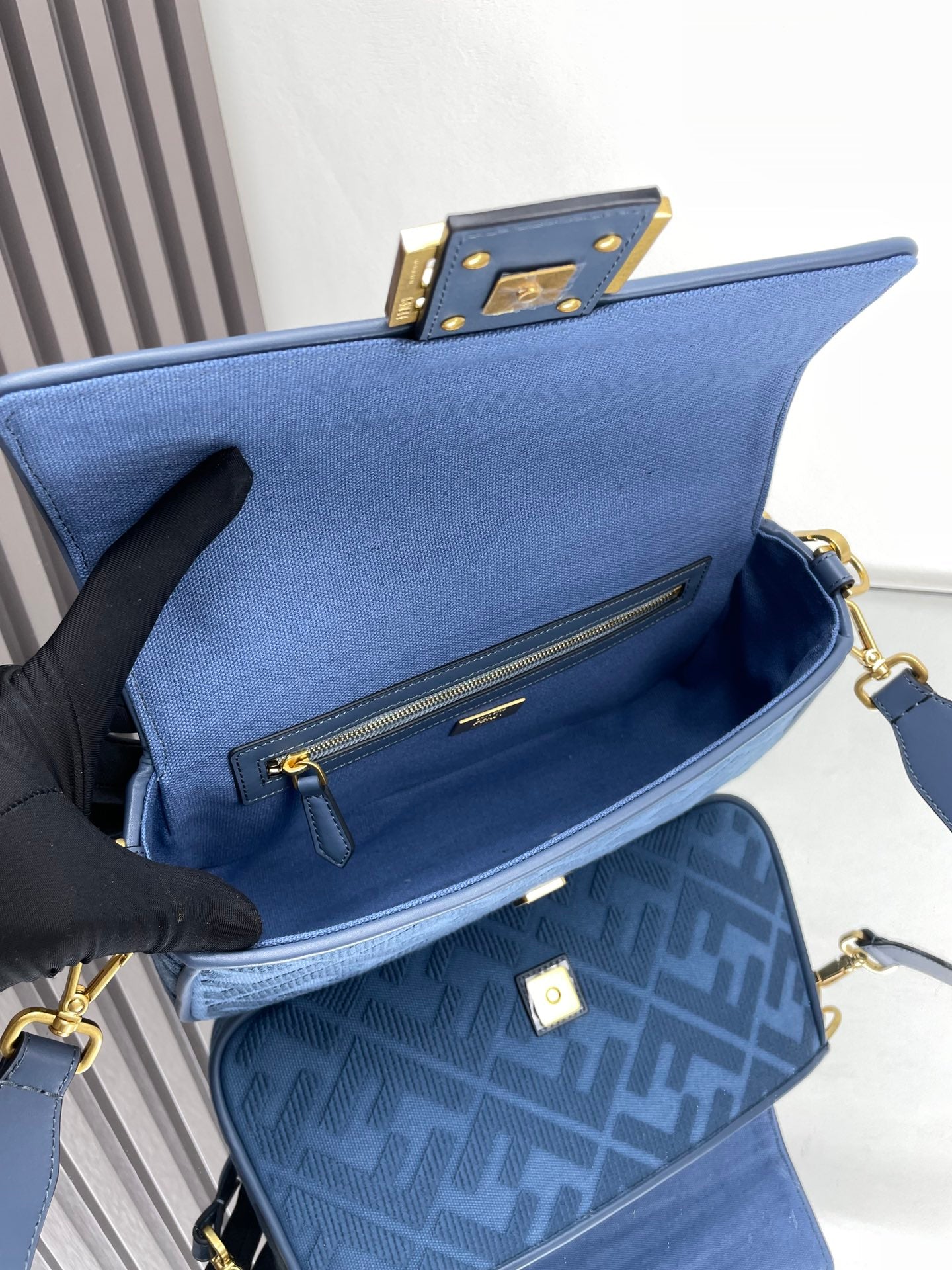 Blue mini shoulder bag with front zipper pocket and gold hardware, open view