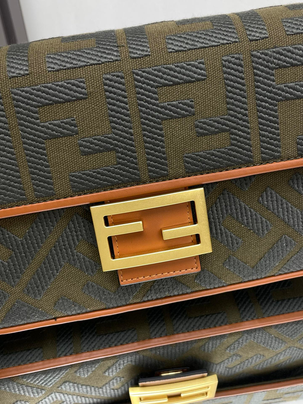 Fendi FF logo bag close-up of gold F emblem on front flap