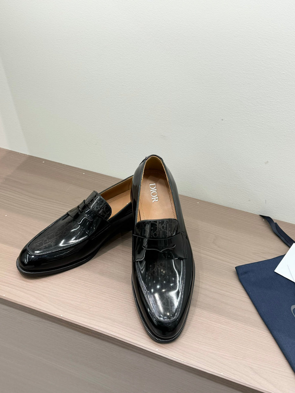 Unisex black patent loafers with front strap buckle, single shoe view