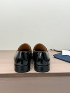 Unisex black patent loafers, back view with heel tabs and stitching