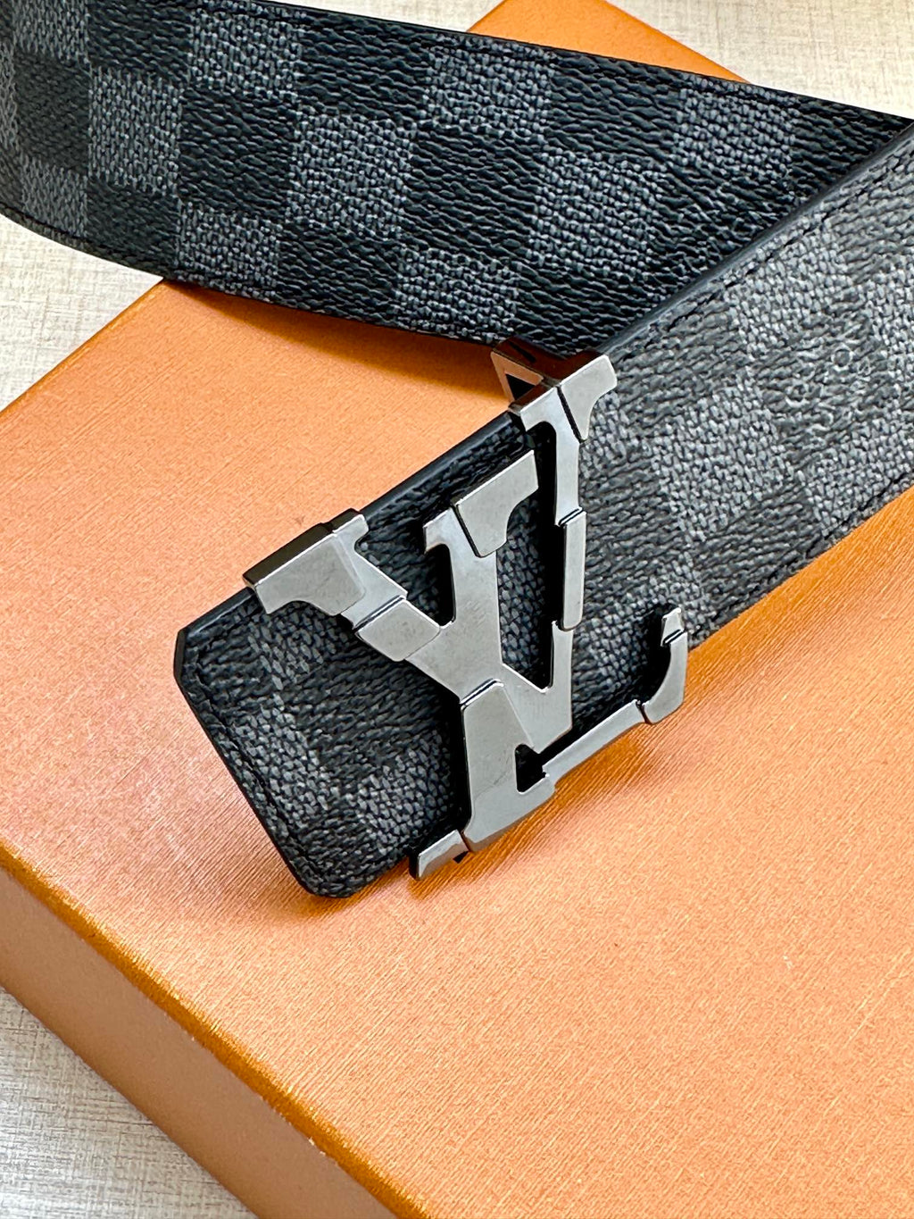 Louis Vuitton patterned belt with large silver buckle and textured dark strap