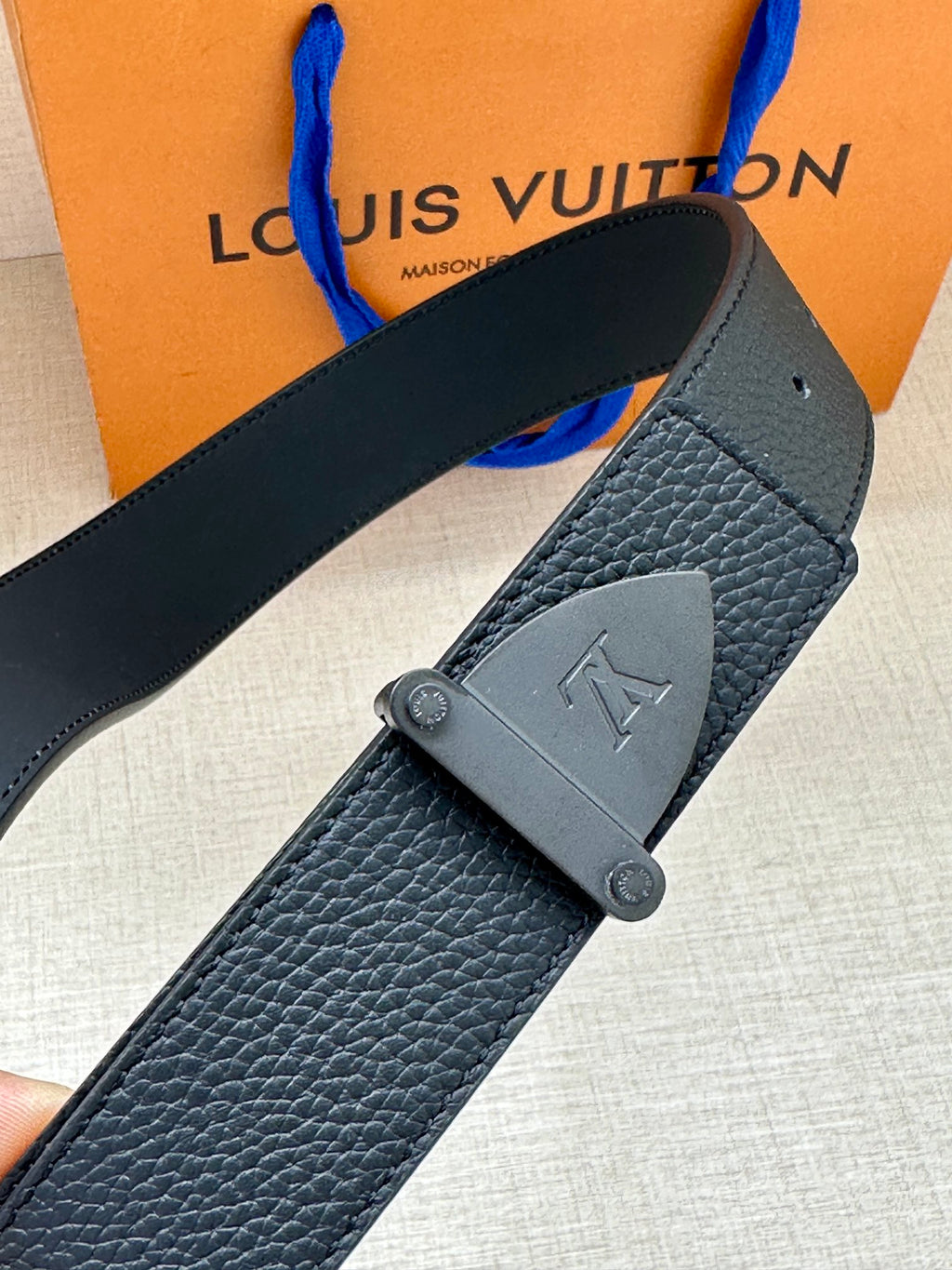 Louis Vuitton dark blue belt detail: textured leather strap and silver LV buckle