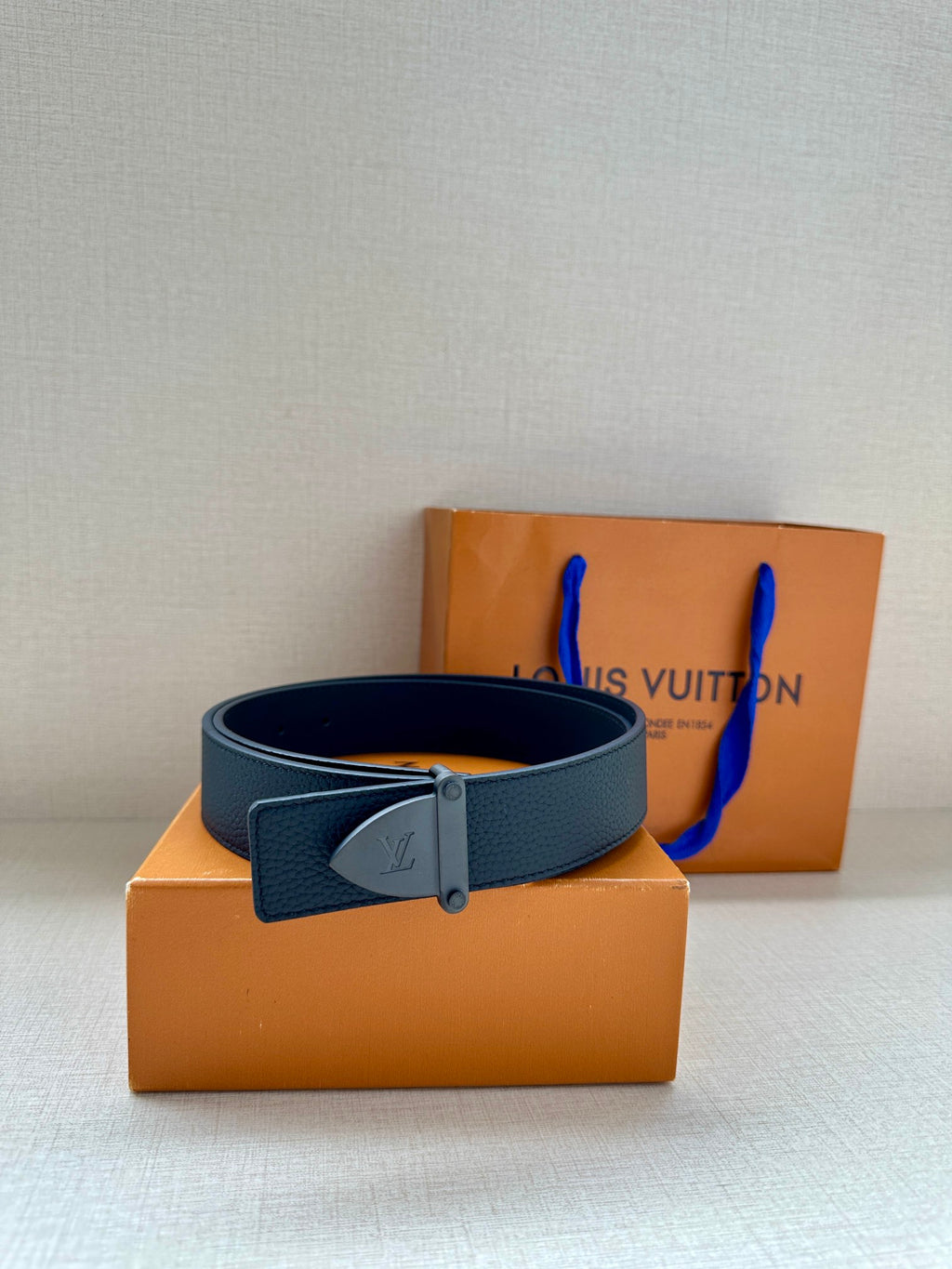Louis Vuitton dark blue leather belt with silver buckle and LV emblem, front view