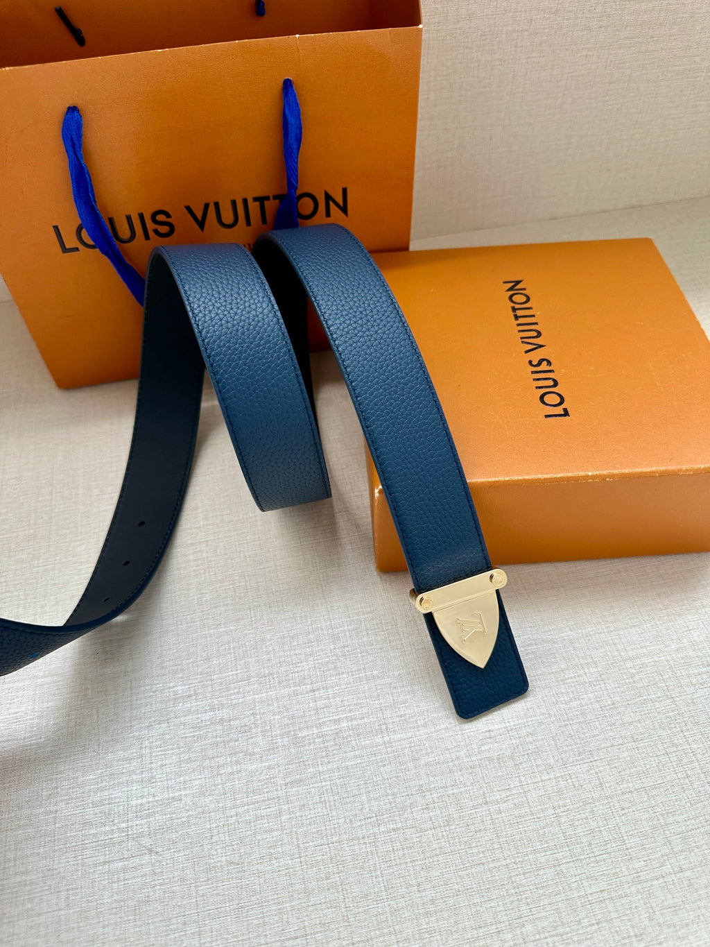 Blue leather belt straps with silver LV buckle and attached leather tag