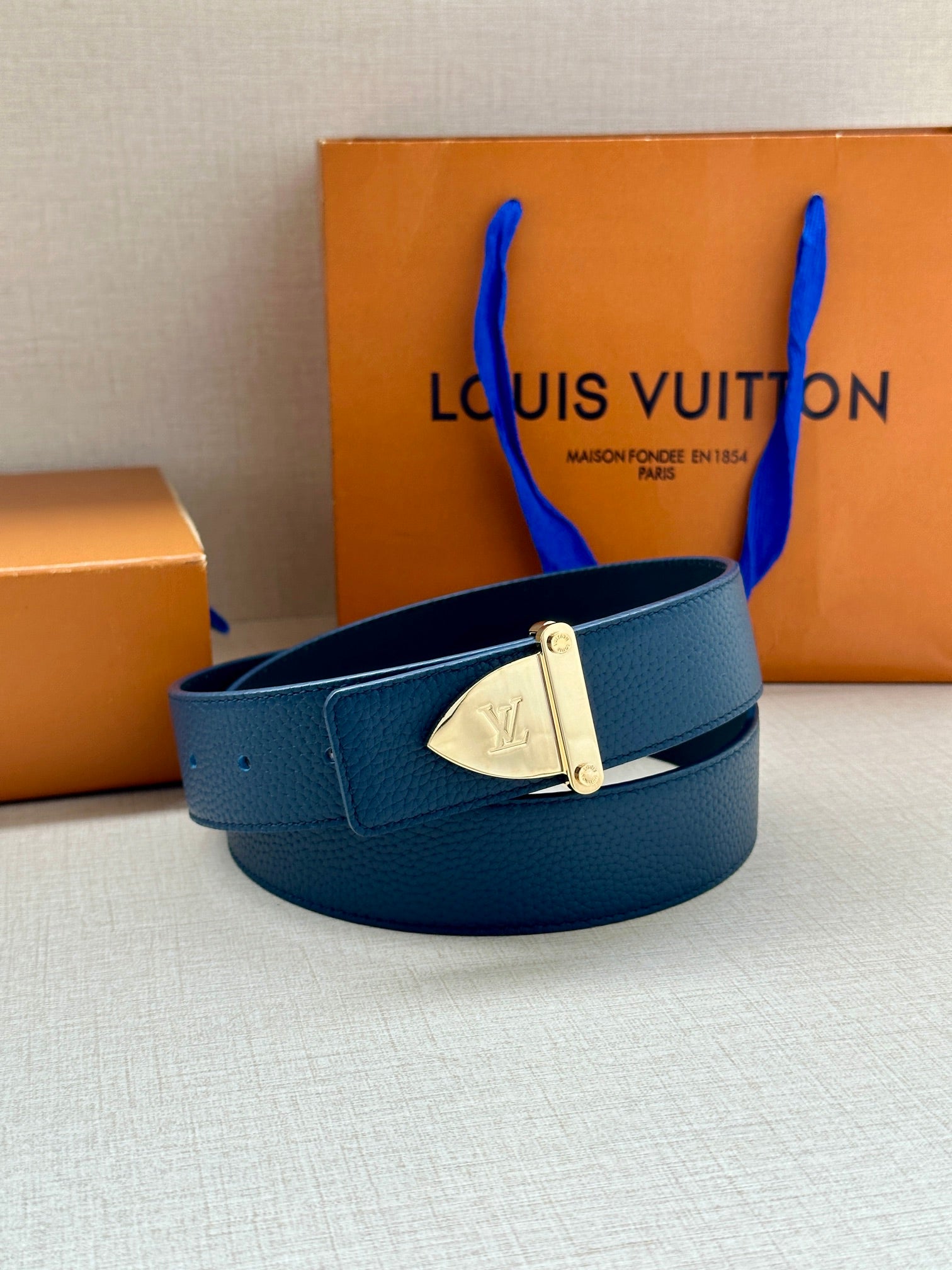 Blue leather belt with silver LV buckle and punched belt holes