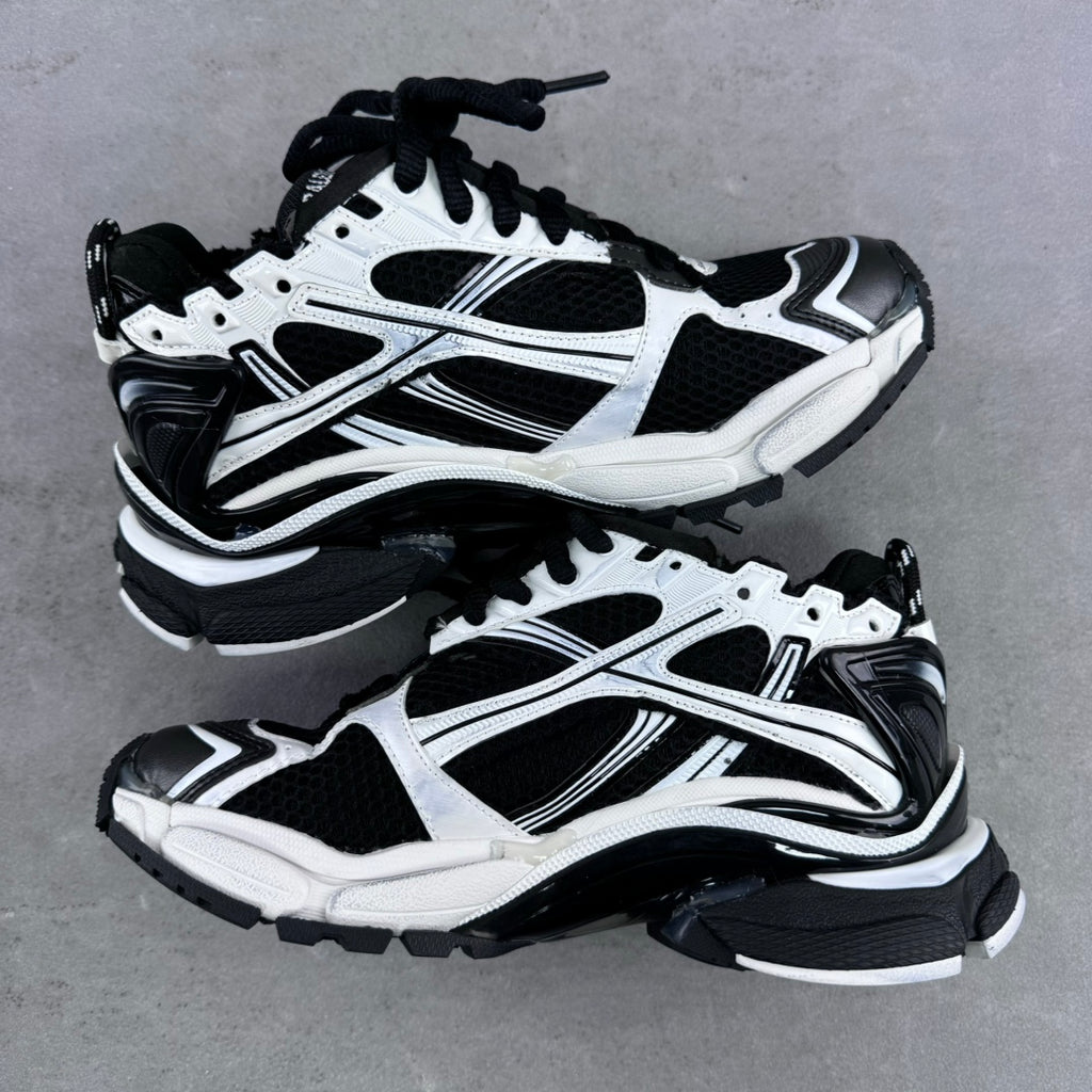 Balenciaga unisex sneaker pair, white and black, side-by-side on gray surface