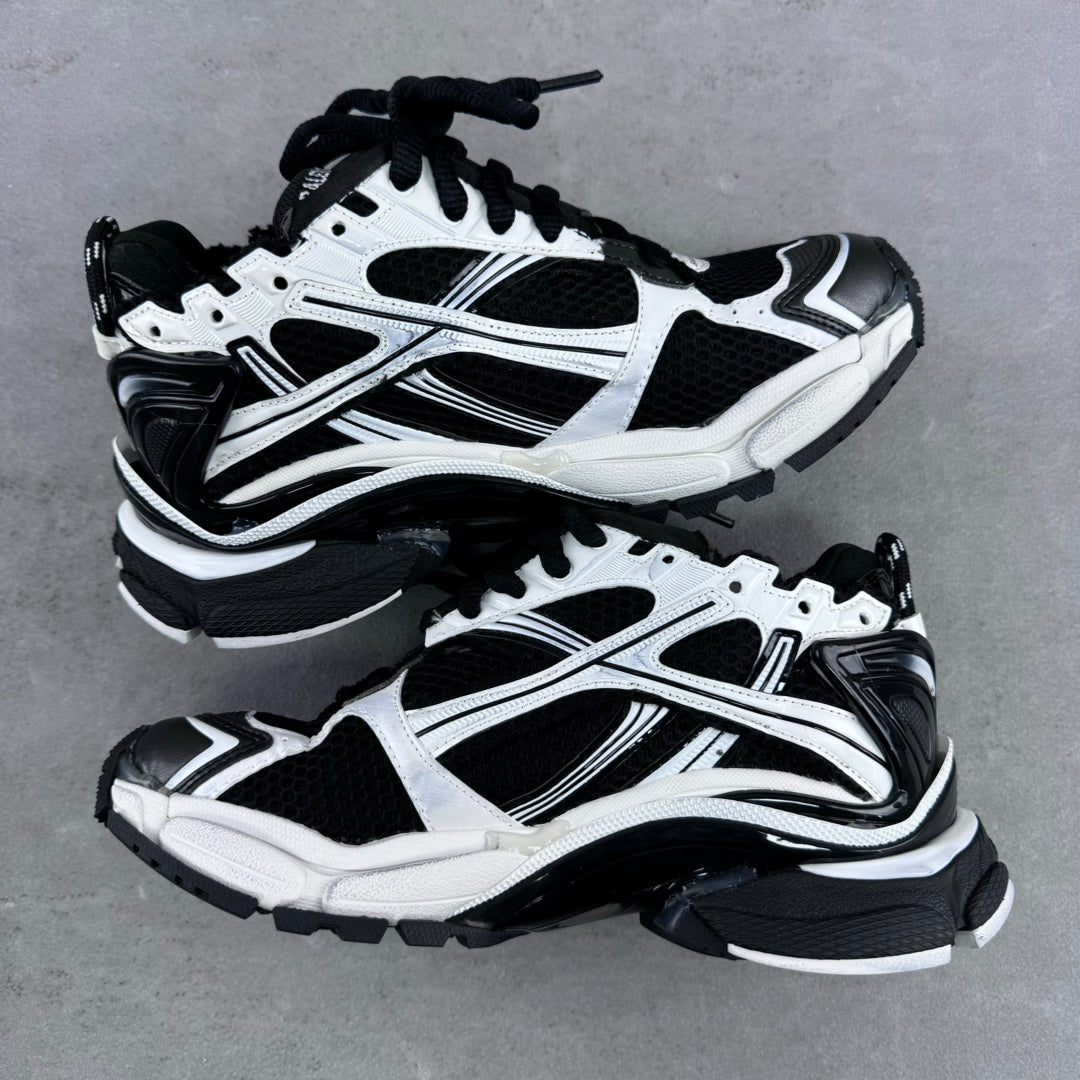 Balenciaga unisex sneaker pair, white and black, side-by-side on gray surface