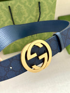 Gucci belt close-up: navy leather strap with embossed pattern and gold-tone GG buckle