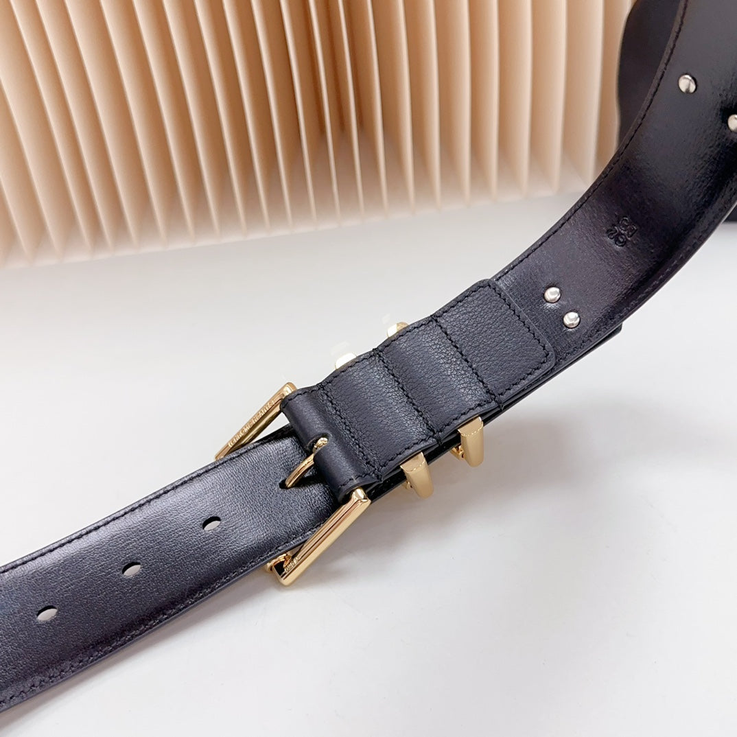 Navy leather belt close-up of gold buckle and central keeper with metal studs
