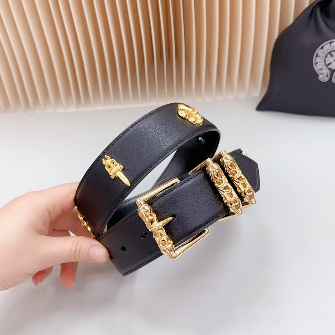 Navy leather belt with gold buckle and ornate charm plates, held in hand