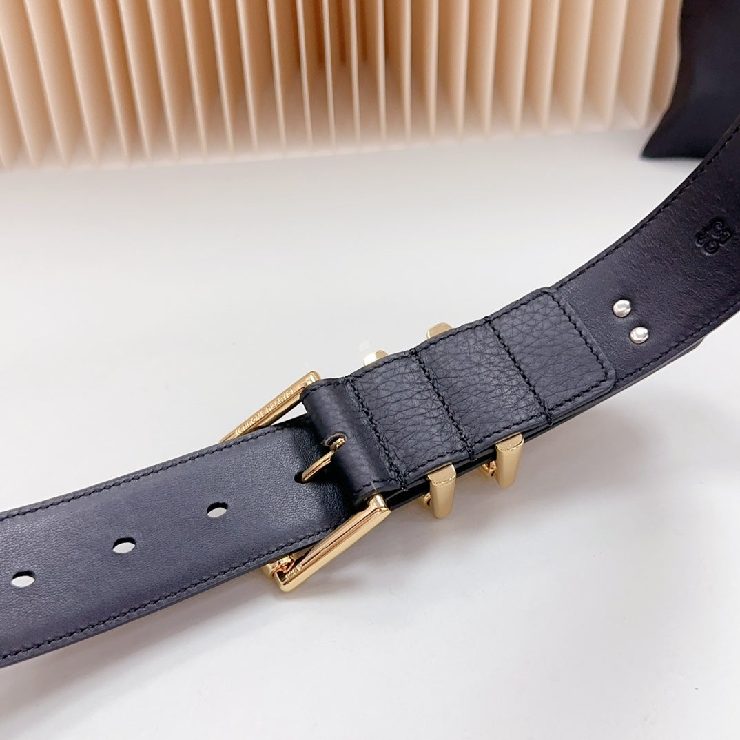 Dark blue leather belt buckle with gold hardware and metal charm studs