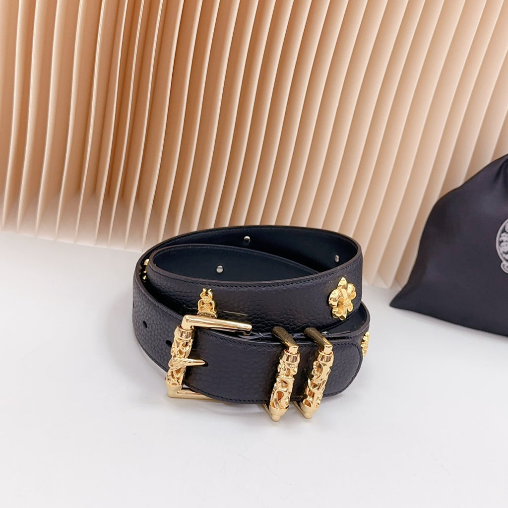 Dark blue leather belt with gold buckle and clover and stud charm accents