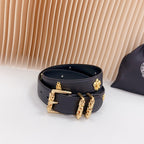 Dark blue leather belt with gold buckle and clover and stud charm accents