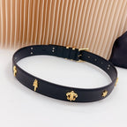 Navy leather belt with gold buckle and star, clover, and small charm details
