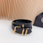 Navy leather belt with gold buckle hardware and cross charms, front view