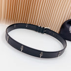 Belt with dark strap, chrome buckle, and small charm accents along the band