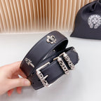 Chrome belt close-up held in hand, dark leather with fleur-de-lis and silver hardware