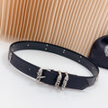 Chrome belt with dark leather and silver buckles, stud trim, and cross charm detail
