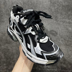 Unisex sneakers with black and white uppers, lace-up closure, BALENCIAGA text on tongue.