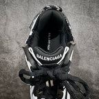 Unisex sneakers heel close-up with BALENCIAGA logo on insole, black laces.