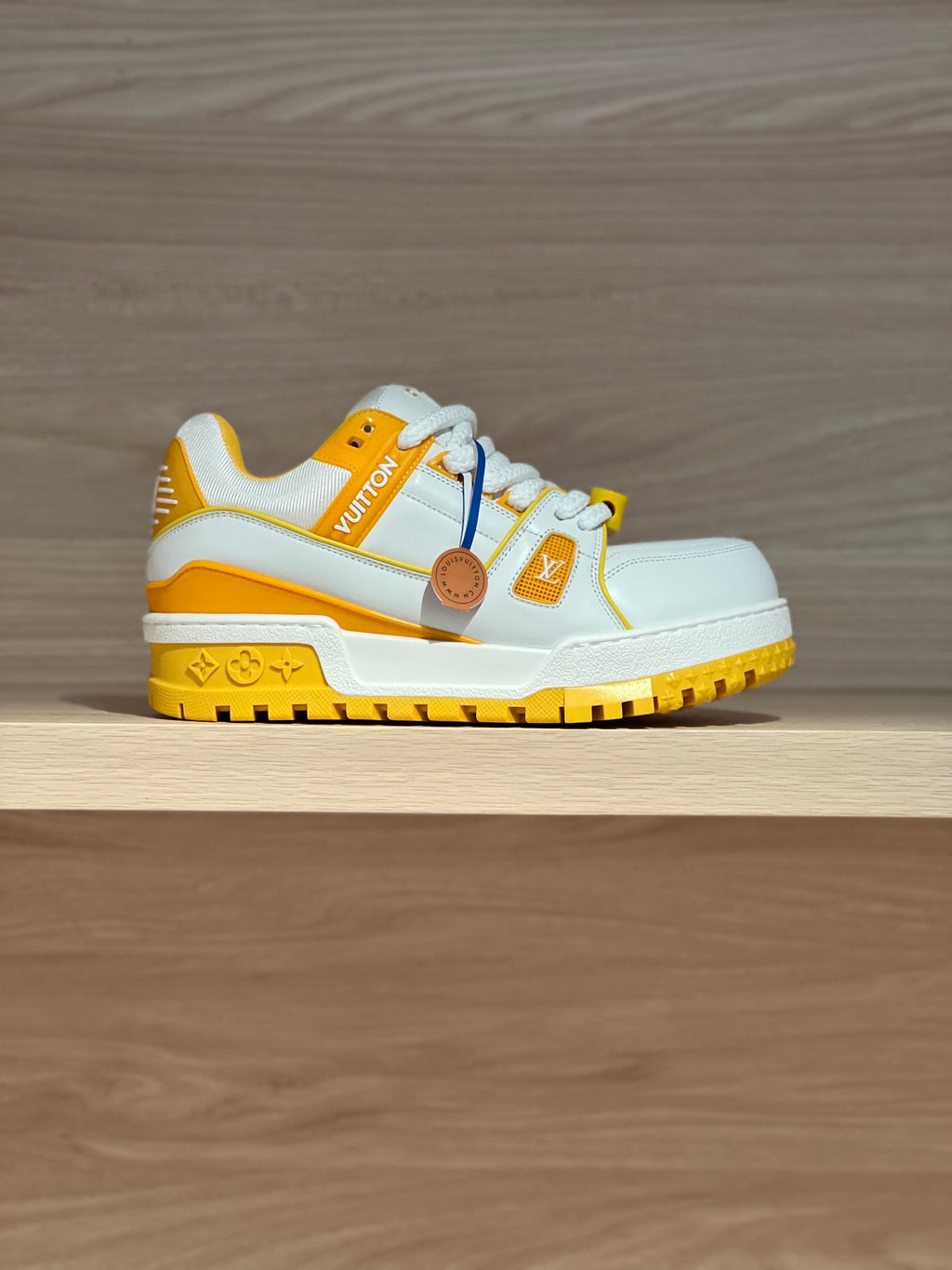 White and yellow low-top trainer sneakers with side emblem and rubber tread sole