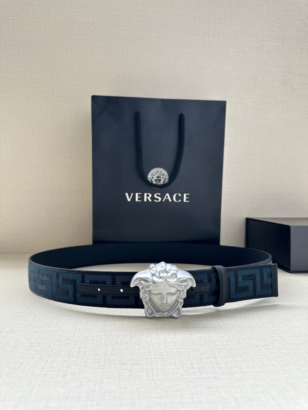 Versace belt in dark blue with Greek key pattern and silver Medusa buckle.