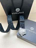 Versace belt close-up: dark blue Greek key straps with silver Medusa buckle.