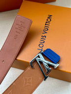 Tan monogram belt with silver LV buckle and blue keeper tab, angled view
