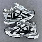Athletic sneakers in grey, white, and black with white laces and chunky soles