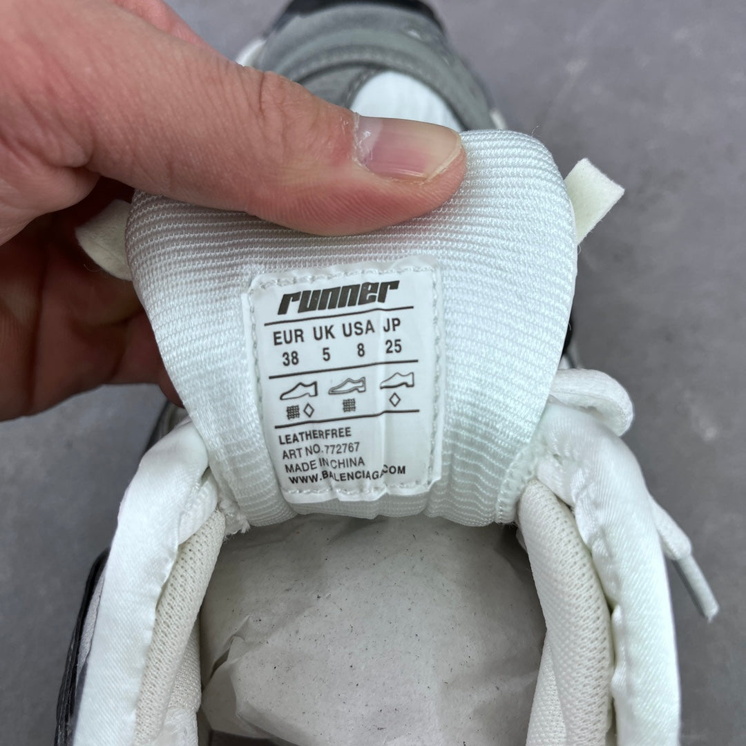 White fabric size tag on athletic sneaker with “EUR/UK/US” and product details