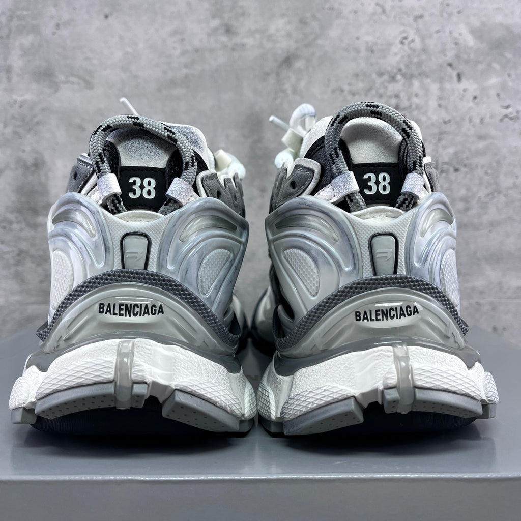 Back view of athletic sneakers with heel tabs, grey trim, and “38” size markings